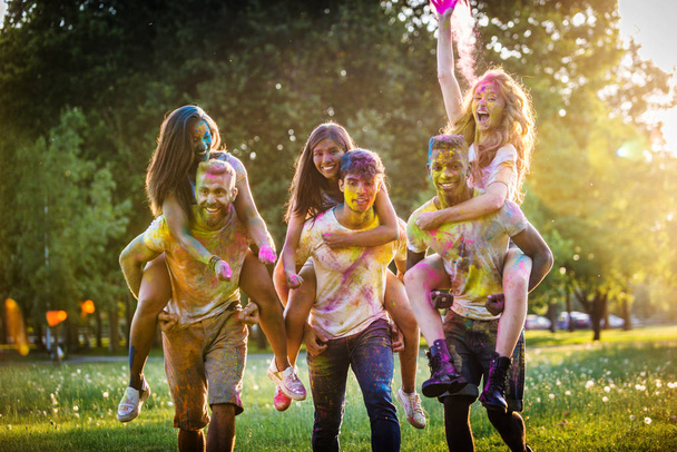 Grupa przyjaciół happy gry z holi kolorów w parku - młodych dorosłych zabawy na festiwalu holi, pojęcia o zabawy, zabawy i młode pokolenie - Zdjęcie, obraz