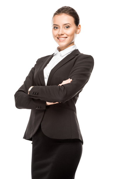 happy young businesswoman in suit looking at camera with crossed arms isolated on white - Fotografie, Obrázek