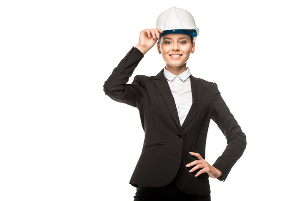 happy young female architect in helmet and suit looking at camera isolated on white - Photo, Image