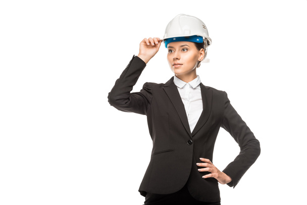 confiant jeune architecte femme en casque et costume regardant loin isolé sur blanc
 - Photo, image