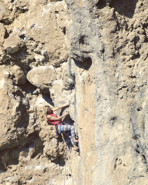 Joven escaladora de rocas en un acantilado
. - Foto, imagen