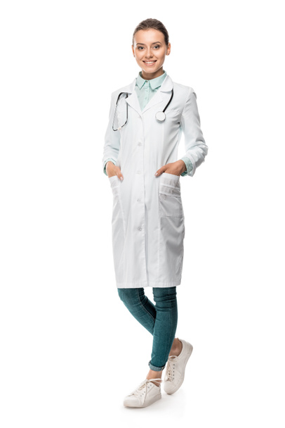 Szczęśliwa młoda lekarka w medycznych płaszcz z stetoskop szyję na białym tle - Zdjęcie, obraz
