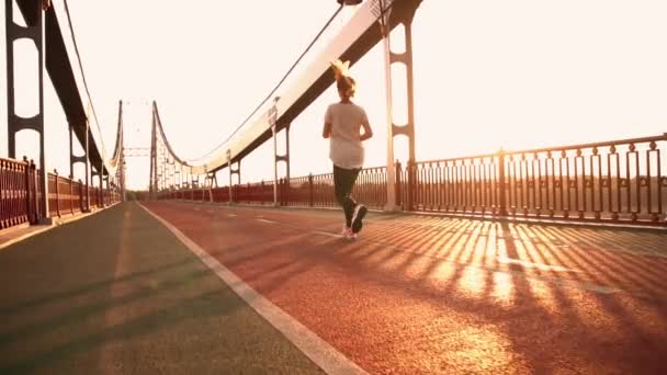 girl is jogging on the bridge - Filmati, video
