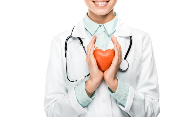 cropped image of happy young female doctor with stethoscope over neck showing heart symbol isolated on white - Foto, Bild