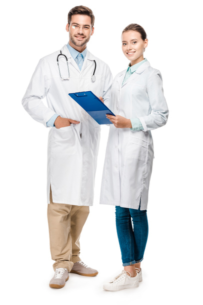 heureux médecin femelle tenant presse-papiers tandis que son collègue masculin debout près isolé sur blanc
  - Photo, image