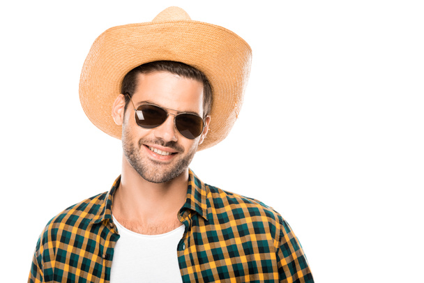 portrait of smiling young male traveler in sunglasses and straw hat looking at camera isolated on white  - Valokuva, kuva
