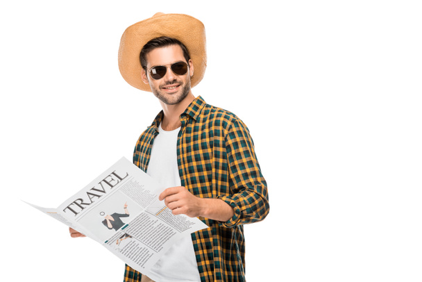 happy young male traveler in sunglasses reading travel newspaper isolated on white  - Foto, afbeelding