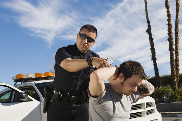 Police Officer Arresting Young Man - Valokuva, kuva