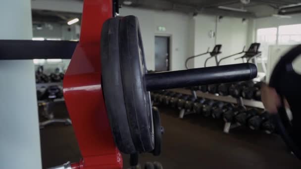 Strong guy hangs weight plates on the place - 映像、動画