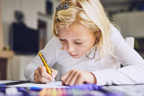 Cute girl writing her homework for elementary school at home. - Fotoğraf, Görsel