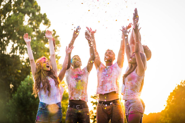 Group of happy friends playing with holi colors in a park - Young adults having fun at a holi festival, concepts about fun, fun and young generation - Valokuva, kuva