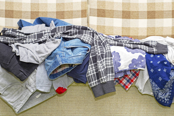 Τσαλακωμένα ρούχα ξαπλωμένη στον καναπέ - Φωτογραφία, εικόνα