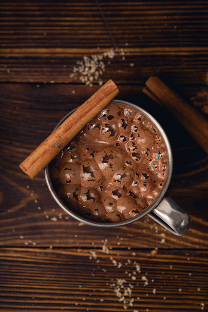 Hot sweet chocolate in mug with cinnamon sticks , close-up  - Fotó, kép