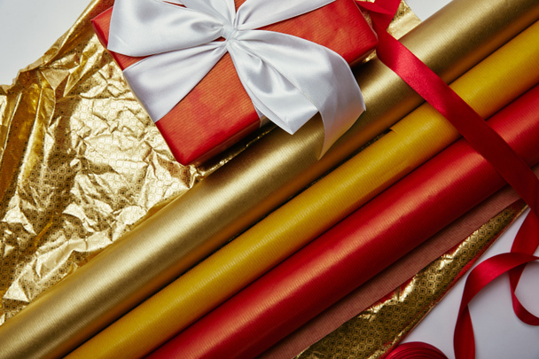 top view of present with ribbon and bright wrapping papers on white backdrop - Photo, Image