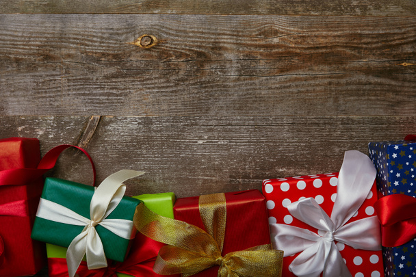 flat lay with presents wrapped in different wrapping papers with ribbons on wooden background - Photo, Image