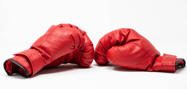 Un par de guantes de boxeo rojos utilizados para entrenar con un saco de boxeo
 - Foto, Imagen