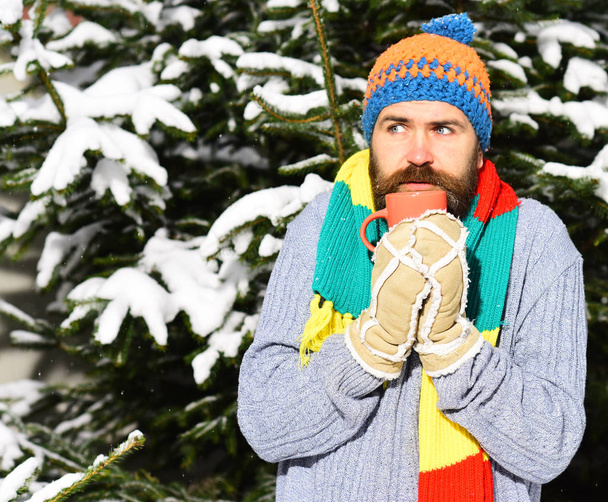 Man wears knitted hat, scarf and gloves with thoughtful face. - Photo, Image