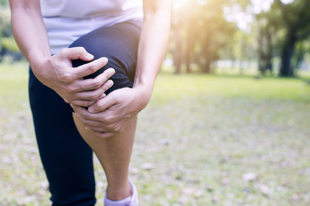 αθλητική γυναίκα, δρομέας έχει πόνο στο γόνατο ή τραυματισμό στο πόδι μετά από προπόνηση και τρέξιμο στο πάρκο - Φωτογραφία, εικόνα