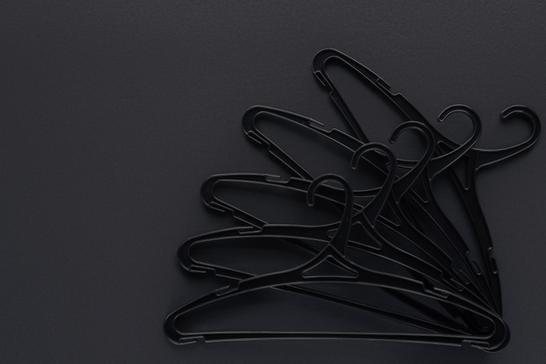 Draufsicht auf schwarze Kleiderbügel für Sonderangebote auf schwarz mit Kopierraum - Foto, Bild