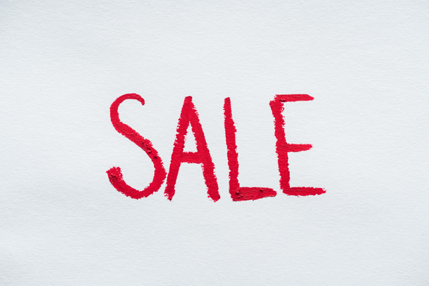 sale symbol written with red lipstick on white - Photo, Image