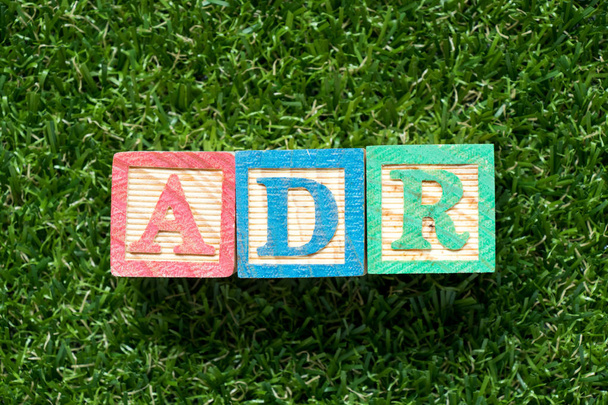 Barevný dřevěný blok v aplikaci word Adr (zkratka nežádoucí reakce) na umělé trávě zelené pozadí - Fotografie, Obrázek