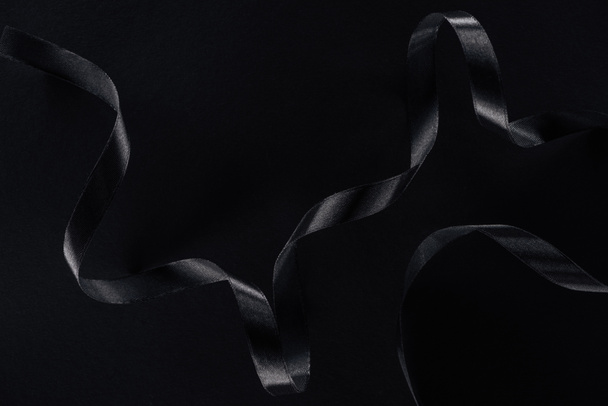 top view of black glossy ribbon on black background  - Fotoğraf, Görsel
