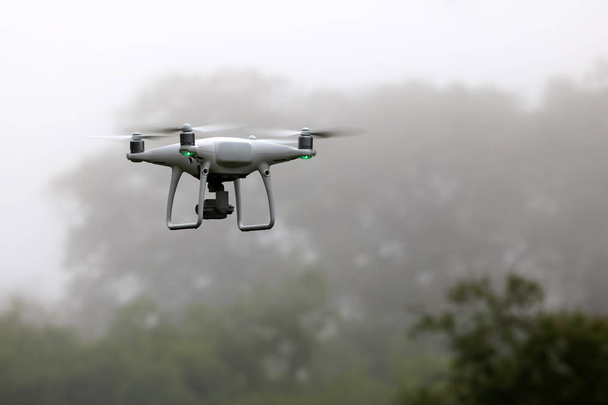 Drone Camera volant dans le ciel tandis que la pluie avec brume, fond de forêts
 - Photo, image
