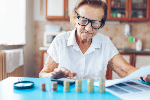 Senior woman at home checking her finances and invenstments - Φωτογραφία, εικόνα