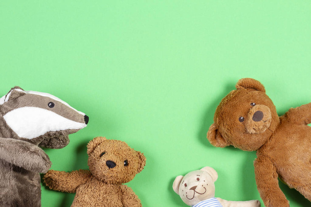 Babyspielzeug-Rahmen mit Teddybär und Stofftierchen auf grünem Hintergrund - Foto, Bild