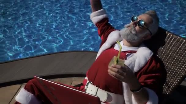 Happy Santa genieten van drinken in de buurt van het zwembad - Video