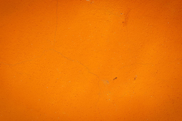 Achtergrond van een oranje stucwerk bekleed en geschilderd buitenkant, ruwe cast van cement en betonnen muur textuur, decoratieve rustieke coating - Foto, afbeelding