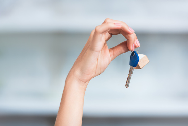 close-up partial view of young woman holding key from new home - Foto, Imagen