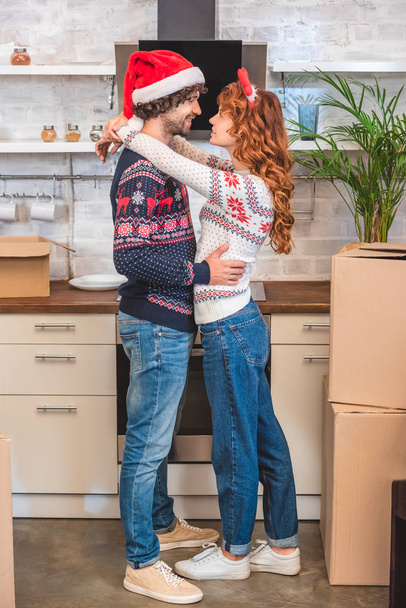 heureux jeune couple embrasser et célébrer Noël ensemble dans nouvelle maison
   - Photo, image