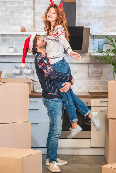 šťastný mladý pár objímání při přemístění na Vánoce v novém domově    - Fotografie, Obrázek