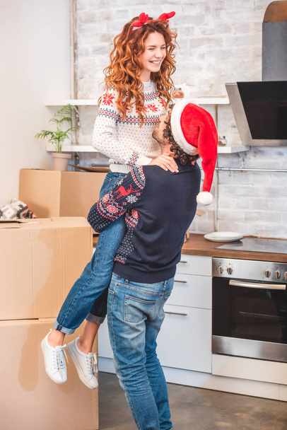 onnellista nuorta paria halaamassa uutta kotia jouluaikaan
  - Valokuva, kuva