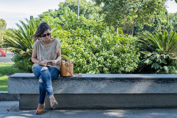 本を読んで石のベンチに座っている女性 - 写真・画像