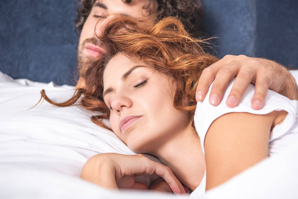 Close-up beeld van mooie jonge paar slapen samen in bed   - Foto, afbeelding