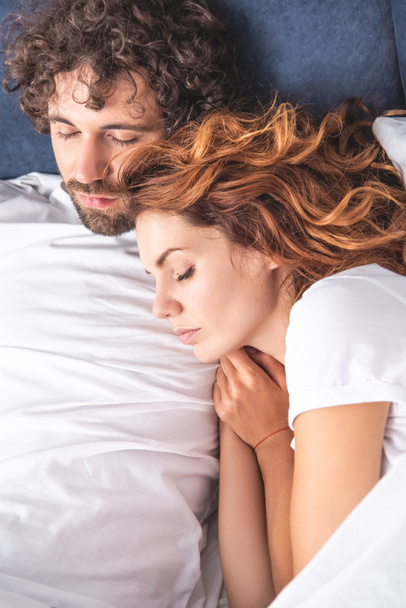 top view of beautiful young couple sleeping together in bed  - Fotó, kép