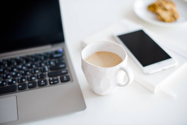 Modern white office, designer handmade cup with coffee, smartpho - Fotó, kép