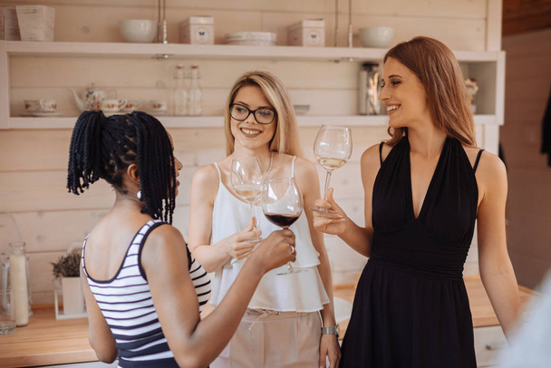 Grupo de jovens amigos felizes bebendo vinho em casa
  - Foto, Imagem