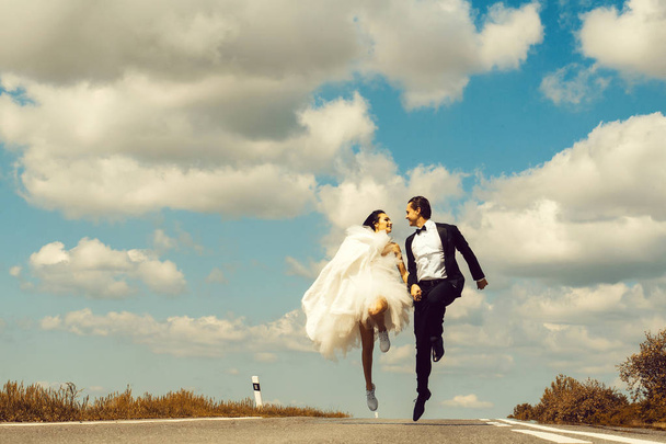 wedding happy couple running on road - Zdjęcie, obraz