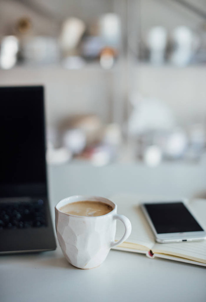 Moderne witte kantoor, designer handgemaakte cup met koffie, smartpho - Foto, afbeelding