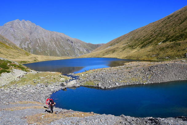 Arkhyz, Russia, Caucasus, September, 20, 2018. Tourists hiking near lake Chilik in clear weather. Russia, Arkhyz  - 写真・画像