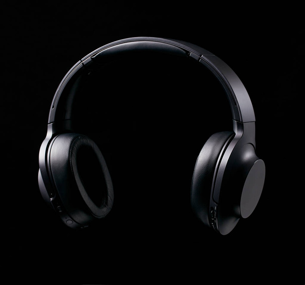 Черные наушники Bluetooth на черном фоне
 - Фото, изображение