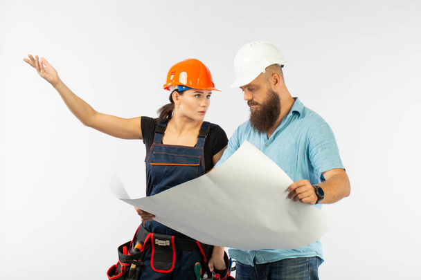 A male architect or engineer meeting with a building woman contractor on white background. The process of discussimg the plam of building. Bisiness concept. discussion of the repair plan - Photo, Image