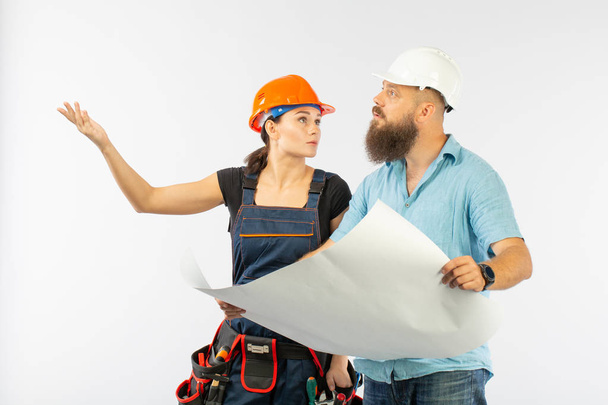 建物の男性建築家またはエンジニア会議白い背景の女性の請負業者。Discussimg 建物の梅のプロセス。事業コンセプトです。修繕計画の議論 - 写真・画像
