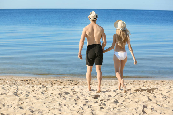 Happy young couple near sea on summer day - Photo, Image