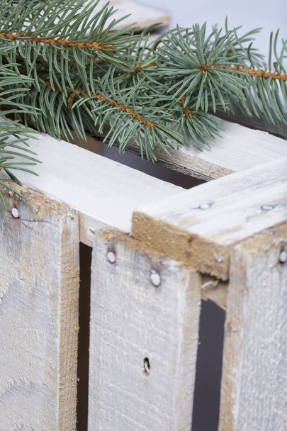 Blue spruce branches on a wooden box of boards, painted in white. - Fotografie, Obrázek