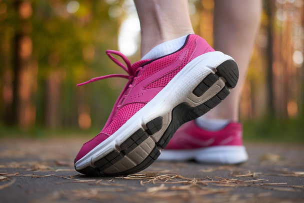 Спорт. Женские ноги в розовых кроссовках на испытаниях в лесу. Крупный план на спортивной обуви бегущей женщины. Концепция запуска
 - Фото, изображение