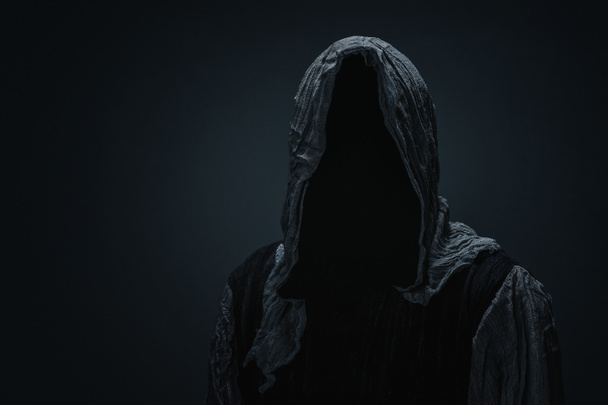 Silhouette of a Grim Reaper over dark gray background with copy space  - Photo, Image